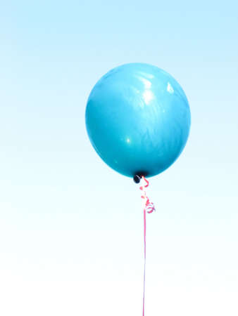 A blue balloon on light sky.の写真素材