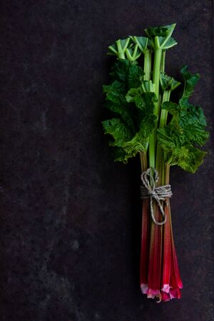 Fresh rhubarb stalks on dark background, top view, copy space.の写真素材