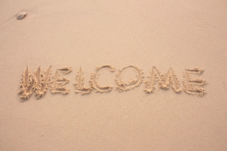 words welcome  written in the sand with fingerの写真素材
