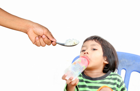 Children who are tired of rice,but he want some milk,focus at rice.の写真素材