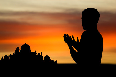 Silhouette muslim people  praying at sunset.の写真素材
