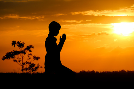 people  praying at the sunset.の写真素材