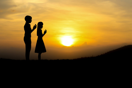 people  praying at the sunset.の写真素材