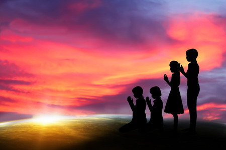 people  praying at the sunset. の写真素材