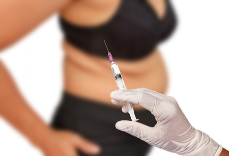 Hand holding syringe concept of weight loss surgery, liposuction.の写真素材