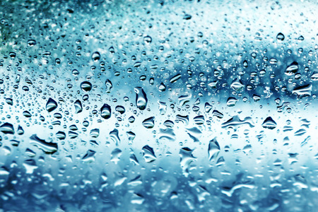 blurred bokeh and water drops on blue mirror backgroundの写真素材