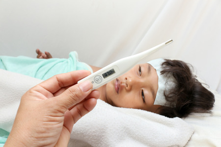 mother holding fever thermometer for a boy ,who has fever 37  Cの写真素材