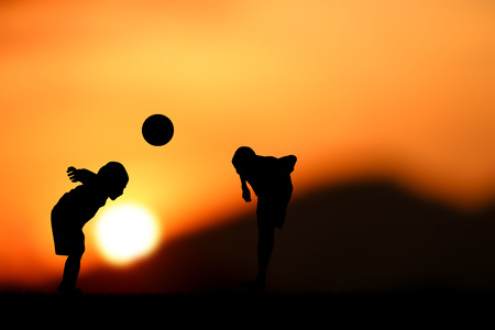 two brothers, boys play ball at sunset.の写真素材