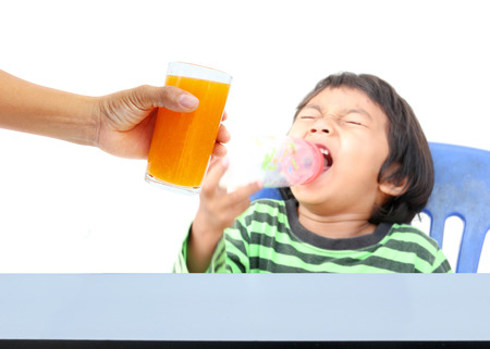 Hand of mother give orange juice for children, who are tired of food,の写真素材