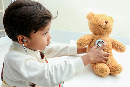 Asian boy play with bear  in the room.の写真素材