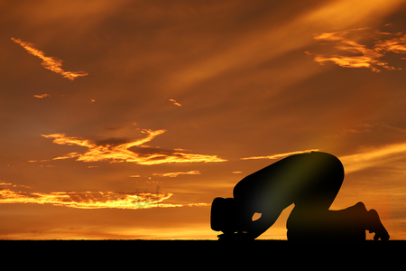 Silhouette muslim people  praying at sunset.の写真素材