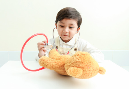 Asian boy play with bear  in the room.の写真素材