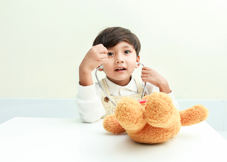 Asian boy play with bear  in the room.の写真素材