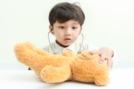 Asian boy play with bear  in the room.の写真素材