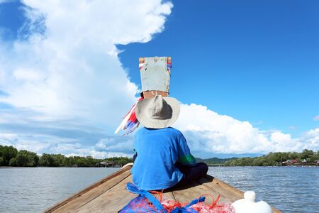 A boy in fishing boat go to the sea at blue sky of the day.の写真素材