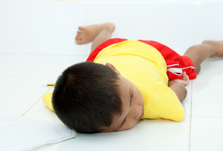 Children who are feeling tired sleep in room.の写真素材