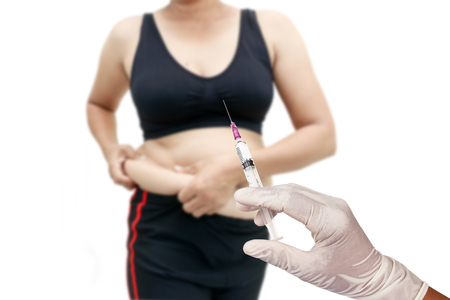 Hand holding syringe concept of weight loss surgery, liposuction.の写真素材