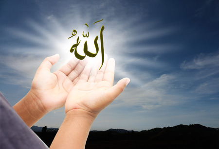 Small hand praying to allah god of Islam on a sunset.The words spell is Allah means the God of...