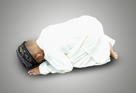 Muslim little cute kid with hat and pray on gray background with clipping path.の写真素材