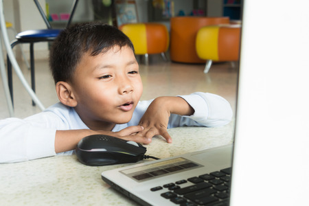 a boy enjoy with computer.