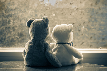 The teddy brown sitting near window at raining and waiting for something,vintage filter style.の写真素材