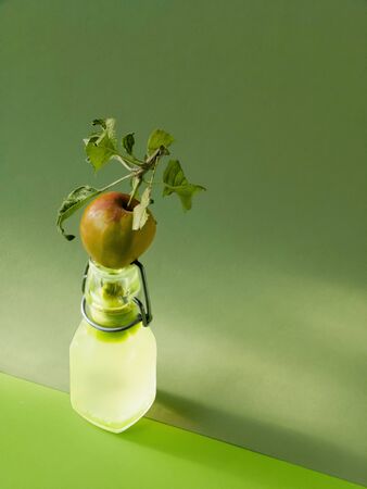 Apple on glass bottle. Green apple looking fresh and healthy.の写真素材
