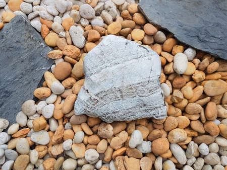 White main stone surrounded by brown, white, and grey pebbles.の写真素材