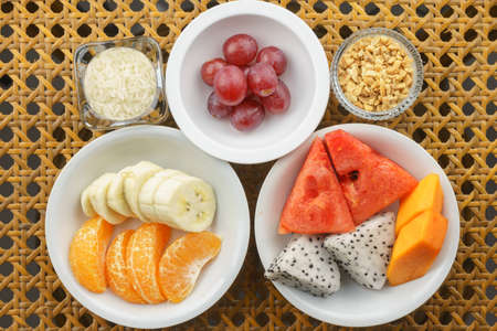 Variety of fruits in different small bowl sizes on the table. It is a vegetarian and vegan food conceptの写真素材