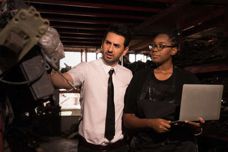 Man work with woman. Diversity of two people, caucasian business manager checking auto part with...