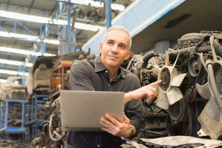 Engineer man working, Caucasian manager with no helmet showing engine propeller to team in factory-warehouseの写真素材