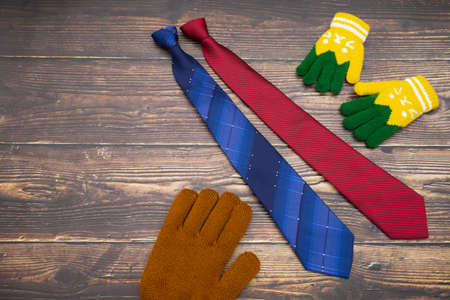 Represent scene of dad receives two tie gifts from son by unbranded gloves with dark wood background. Background scene of child gives happy gift to father in father's day conceptの写真素材