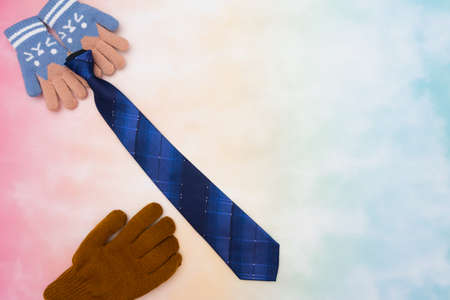 Happy family scene of daughter holds and gives tie gift to father in father's day with colorful background. Represent daughter by unbranded gloves at top and dad by one unbranded glove at bottomの写真素材