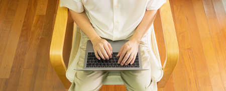 High angle view of anonymous professional business man smart work at home by sitting and using notebook or laptop to communicate employee or worker via online internet network on computer.の写真素材