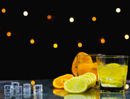 ice and slice fresh lemon beside lemon juice glass on table, bartender prepare fruit cocktail or fresh juice for drinking in party at barの写真素材