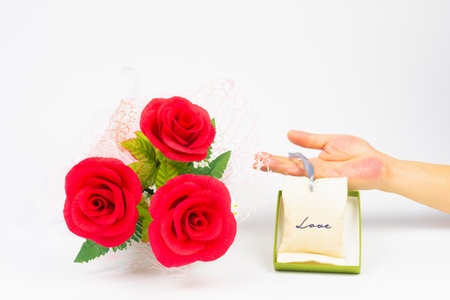 red rose flower in bunch with love bag in hand in green lid gift box on white background, beautiful elegance red roses flower of love inspiration in anniversaryの写真素材