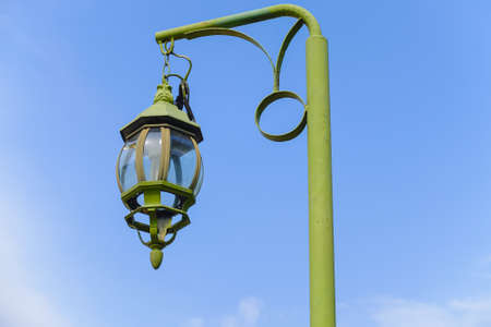green vintage lamp and lamppost under blue sky, old retro lantern on garden street at park in asia-thailand for outdoor lightの写真素材