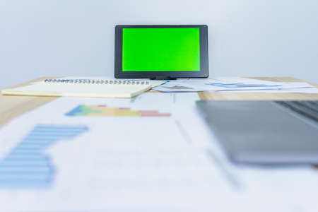 green screen on tablet near notebook, graph document, laptop for making presentation, professional worker busy work on the business graph dataの写真素材