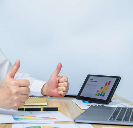 executive â€‹work with data graph on tablet and give thumbs up for business success with copy...