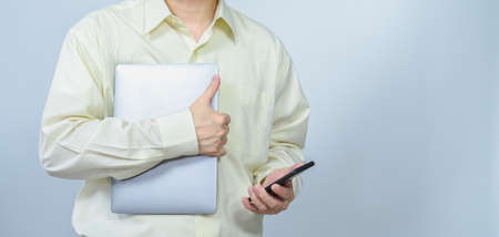 man hold laptop and mobile with right white copy space background, professional businessman busy work on the businessの写真素材