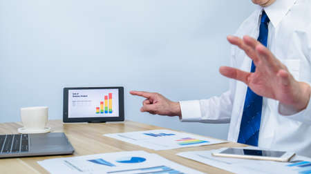 executive meeting and showing business success of sale graph on tablet with white copy space background for making meeting presentation, professional businessman busy work on the business data graphの写真素材