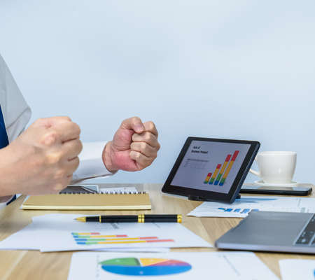 executive âwork with data graph on tablet and happiness on business success with copy space background for making meeting presentation, professional businessman busy work on the business data graphの写真素材