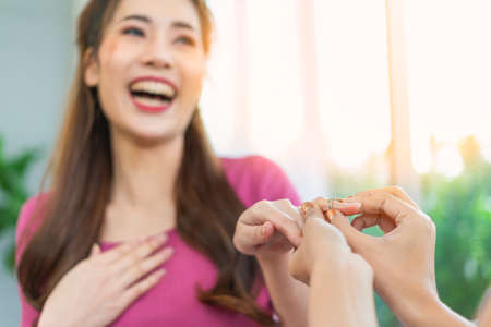 young lgbt women happy to get wearing wedding ring in living room at home, lifestyle of couple lgbt...