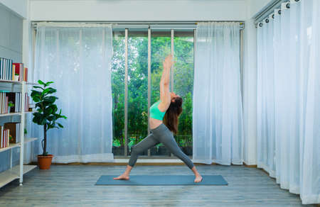 young lgbt women exercise, stretch arms and spread legs on yoga mat at home, lifestyle of couple lgbt loving women happy and fun in yoga sportsの写真素材