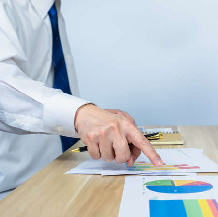 vertical of executive âpoint data graph on document on working desk by hand with white copy space for making meeting presentation, professional businessman busy work on the business data graphの写真素材