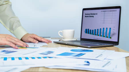 man work busy on laptop and document data graph on working desk, professional businessman busy work on the business data graphの写真素材