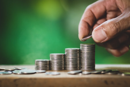 Man hand putting coin to money, business and finance concept idea.の写真素材