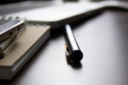Notebook and pen on a wooden table. Selective focus.の写真素材