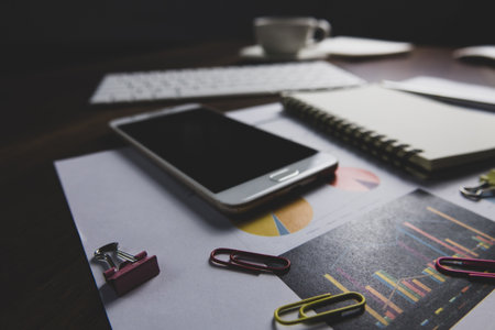 Office table with smart phone, supplies and coffee cup, stock photo