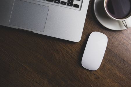 Office workplace with laptop and coffee cup on wooden table. Top viewの写真素材