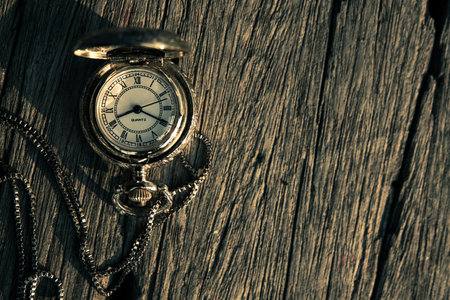 Vintage pocket watch on wooden background with copy space. Time conceptの写真素材
